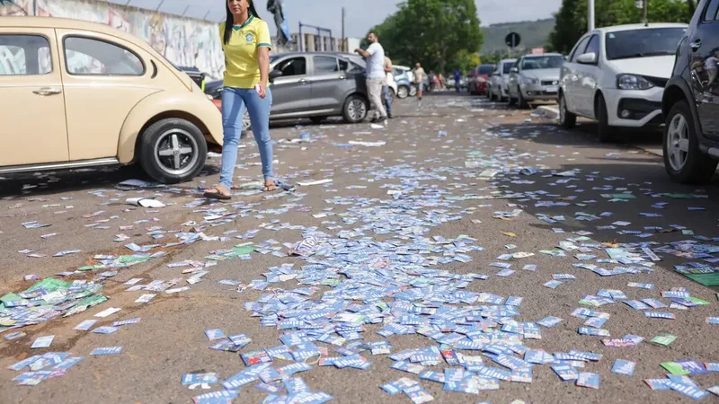Brasília (DF), 04/10/2026 - Material de propaganda eleitoral é encontrado espalhado em frente a uma escola durante o primeiro turno das Eleições 2026, neste domingo. 
A distribuição de santinhos e a prática de boca de…