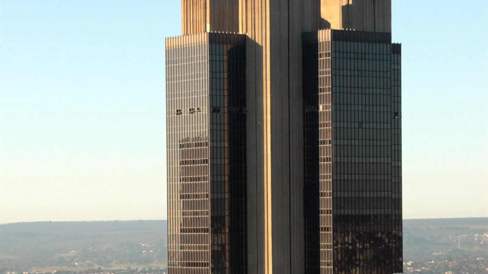 Torre escura do edifício-sede do Banco Central do Brasil vista de longe